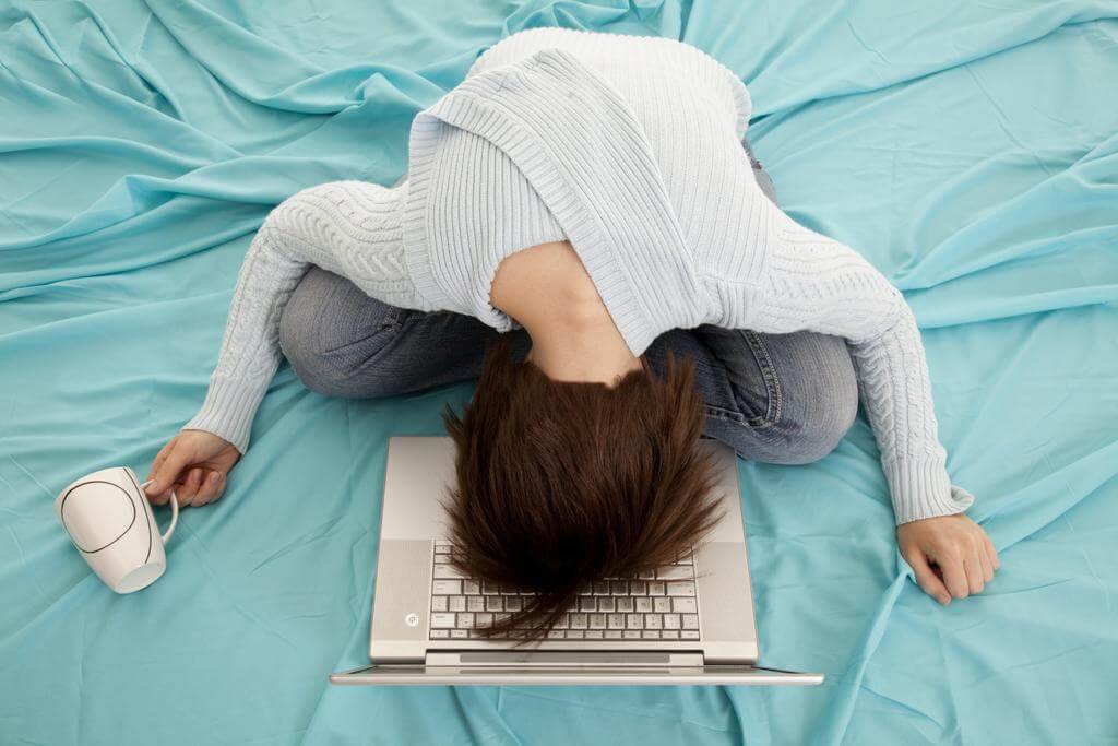 Nő az ágyban fáradt szemét a laptopra hajtja