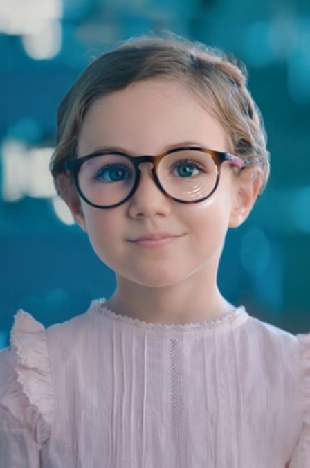 Gyönyörű kislány szemüvegben néz a kamerába