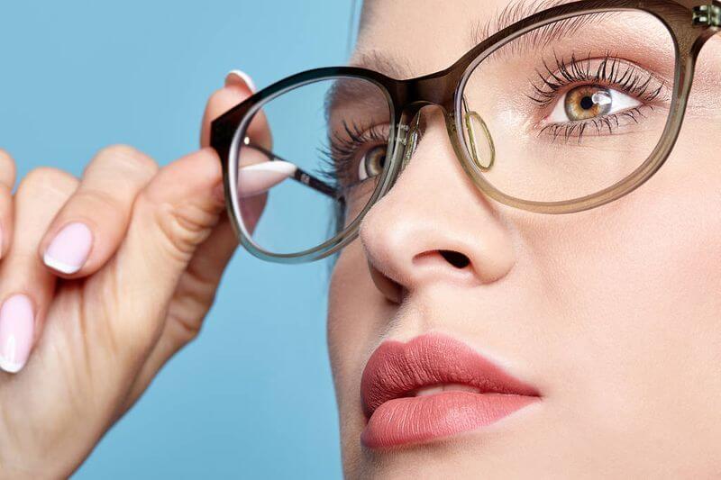 Fiatal nő műanyag szemüvegét igazgatja 
